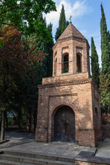 Fototapeta na wymiar The ancient brick bell tower of St. George Kari in the historical part of the city of Tbilisi. Georgia