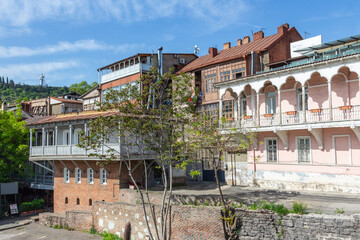 Fototapeta na wymiar A view of a historic house with a beautiful wooden balcony in the Old Town of Tbilisi. Georgia