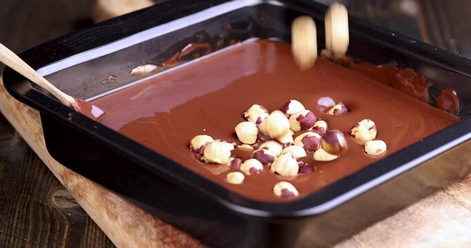 making chocolate from high-quality cocoa and cocoa butter with hazelnuts, adding roasted hazelnuts to melted liquid chocolate