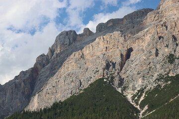 Coravara, Italy-July 16, 2022: The italian Dolomites behind the small village of Corvara in summer days with beaitiful blue sky in the background. Green nature in the middle of the rocks.