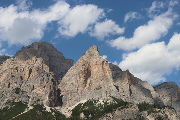 Fototapeta na wymiar Coravara, Italy-July 16, 2022: The italian Dolomites behind the small village of Corvara in summer days with beaitiful blue sky in the background. Green nature in the middle of the rocks.
