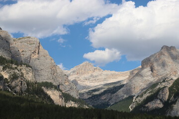 Coravara, Italy-July 16, 2022: The italian Dolomites behind the small village of Corvara in summer days with beaitiful blue sky in the background. Green nature in the middle of the rocks.