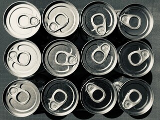 arranged tin cans with opener from above in black and white