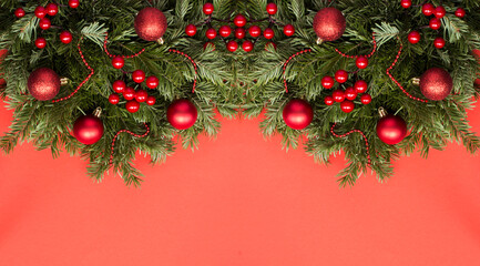 Fototapeta na wymiar Christmas banner with spruce branches and red bead on the red background. Copy space.