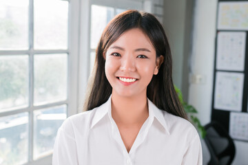 Attractive Asian businesswoman smiling confidence standing and looking at camera in office.