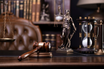 Law theme - judge office. Themis and gavel  on the judge desk. Book shelf  in the background.