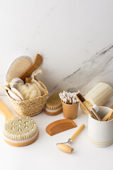 Wooden toothbrushes with natural bristles in a ceramic glass, face and skin care products, bath accessories, spa and beauty concept