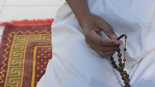 religious arab muslim man hold rosary wooden bead in hand for determine the number of prayer services to god allah in islam religion, concept for believe, trust, hope, peace in ramadan mubarak month