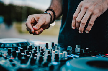 DJ Hands creating and regulating music on dj console mixer in concert outdoor