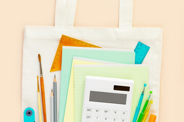 Back to school flat lay with multicolored notebooks, pens, brushes, rulers and calculator on a...
