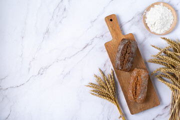 Freshly baked rye bread isolated on light background and flour, top view. Copy space