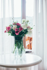 bouquet of flowers in a transparent vase on the table against the background of the window
