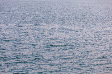 Blue turquoise transparent water surface of a sea with small waves