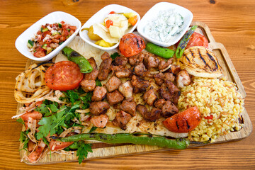 Beef steak grill with rice pilaf, fried potatoes, grilled pepper and tomatoes.Mix Platter with Beef rips, Cutlets, Potatoes and Sauces.