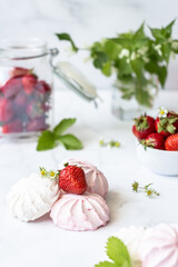 Red and white marshmallows and strawberries on a white background