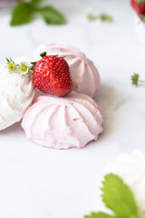 Ripe strawberries and red and white marshmallows on a white background