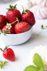 Ripe strawberries close-up in a white cup on a white background