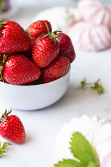 Ripe strawberries close-up in a white cup on a white background