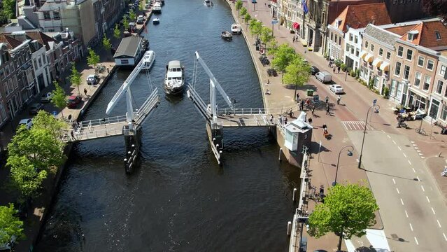 Boat passing under the bascule bridge in dutch city Lemmer, in the summer. Sailboats and yachts pass under the drawbridge. Famous place to visit in Holland. 