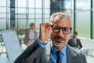 Businessman with colleagues in the background in office.