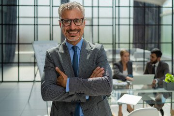 Businessman with colleagues in the background in office.