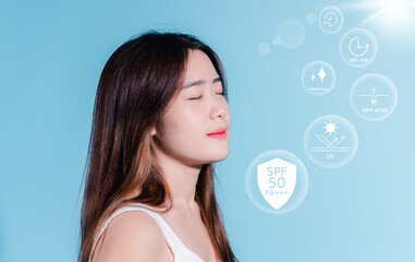 Charming asian beauty woman hold sun cream with sun protection uv or sunscreen, sun block on the blue background