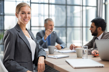 Business woman with her staff, people group in background at modern bright office indoors.