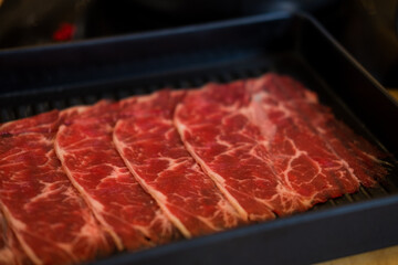 Thinly sliced of raw beef on tray prepare for customer cook Shabu Shabu or Sukiyaki.