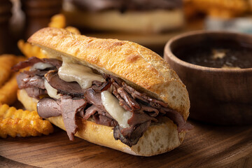 French dip sandwich and bowl of au jus - 521809572