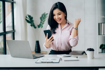 Young asian businesswoman beautiful charming smiling and talking on the mobile phone in the office.