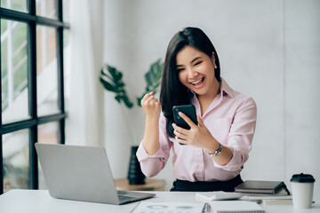 Young asian businesswoman beautiful charming smiling and talking on the mobile phone in the office.