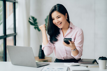 Young asian businesswoman beautiful charming smiling and talking on the mobile phone in the office.