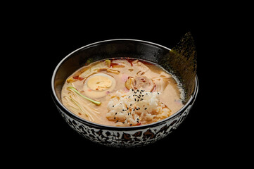 Kimchi Tige soup in a deep dish on a black isolated background