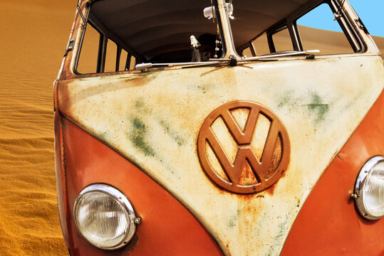 Hannover, Germany, July 23, 2022: Helmstedt, German, July 17, 2022: Old weathered rusty dirty VW Bus T1 without windows in front of a sand dune in the desert