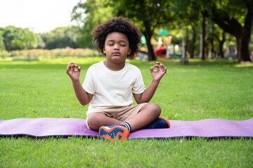Portrait African American kids boy training yoga meditate in the park	