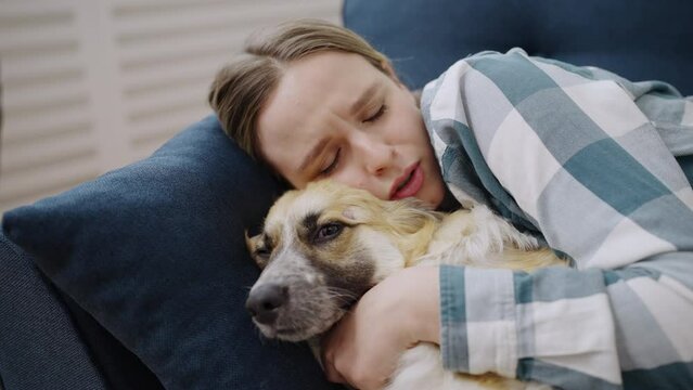 Closeup of upset young woman hugging her dog, pet therapy, welsh corgi