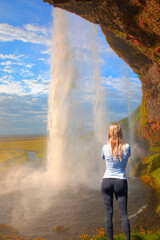 Beautiful girl take a selfie - Icelandic Landscape concept - View of famous Amazing Seljalandsfoss waterfall in Iceland