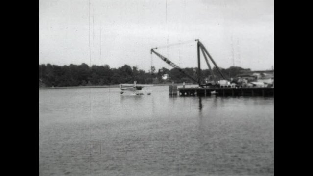 Float Plane Retrieval 1931 - A crane hoists a biplane out of the water at the US Naval Academy in Annapolis, Maryland in 1931. 