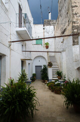 n tipico cortile dai muri bianchi in un borgo del Salento in Puglia sotto un cielo grigio