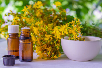 St. John's wort flower oil in a glass bottle. on a wooden background.