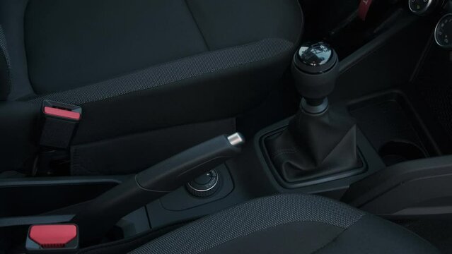Handbrake lever and gear lever in cabin of modern car. Dark gray color color interior