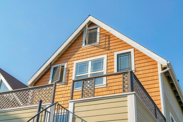Low angle view of a house with wood shingles wall sidings and side hinged windows
