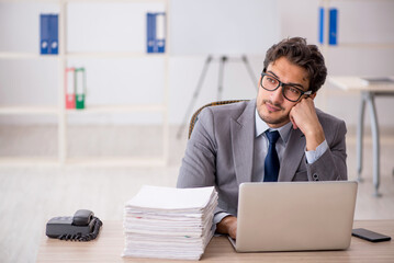 Fototapeta premium Young male employee sitting at workplace