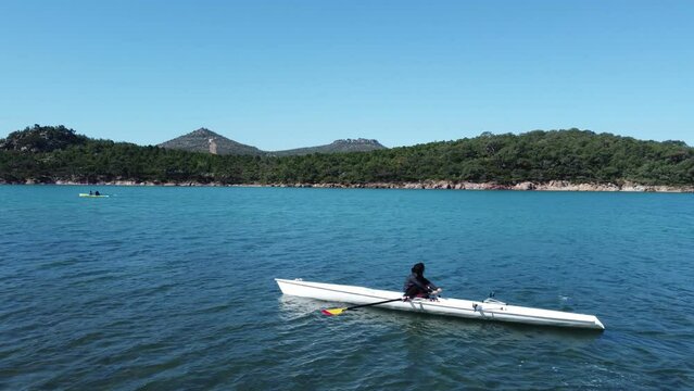 Drone footage of A woman single rowing in the sea
