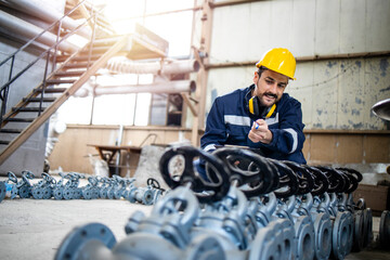 Caucasian worker inspector checking quality of industrial valves before distribution.