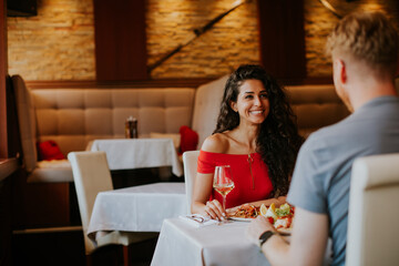 Young couple having lunch with white wine in the restaurant