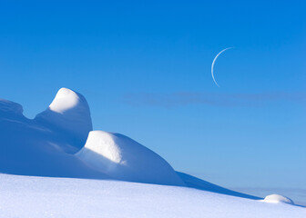 Snowy winter arctic landscape, crescent moon in the blue sky.