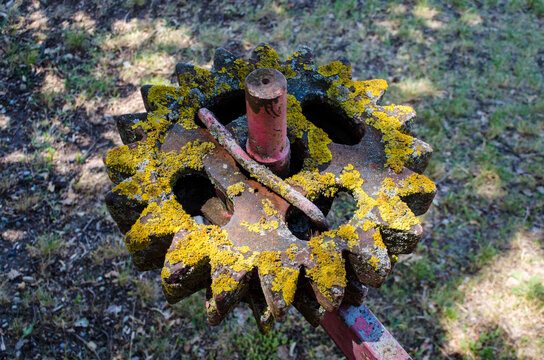 La ruota arrugginita di un ingranaggio agricolo in un campo