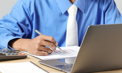 Fototapeta premium Businessman analyzing business plan documents and laptop computer on desk. Work planning concept