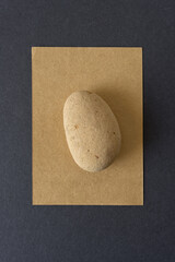 rounded stone (worn brick) isolated on gold paper with frame